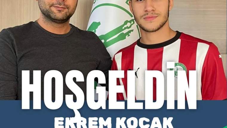 Yan yana duran iki erkekten biri kırmızı-beyaz formasıyla, arkalarında “HOŞGELDİN EKREM KOÇAK” yazısı bulunuyor.