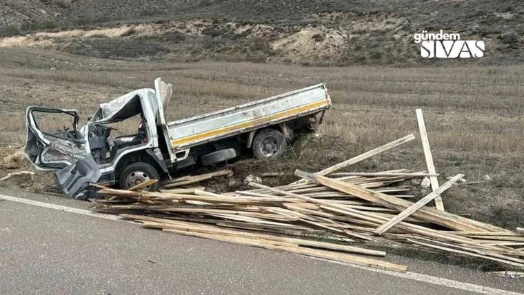 Yolda devrilmiş bir kamyonet, etrafında dağınık odunlar var.