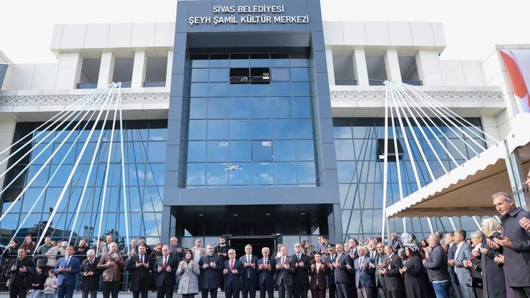Üzerinde “Sivas Belediyesi Şeyh Şamil Kültür Merkezi” yazan binanın önünde alkışlayan kalabalık