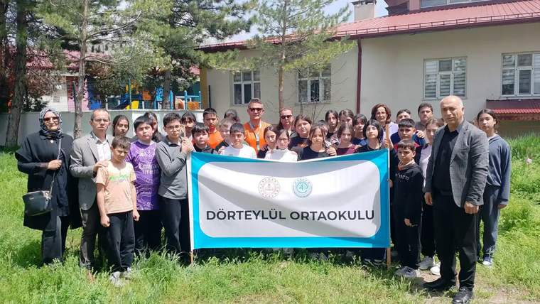 Dörtyol Ortaokulu öğrencileri, fidan dikimi etkinliğinde bir araya gelerek toplu fotoğraf çekiliyor.