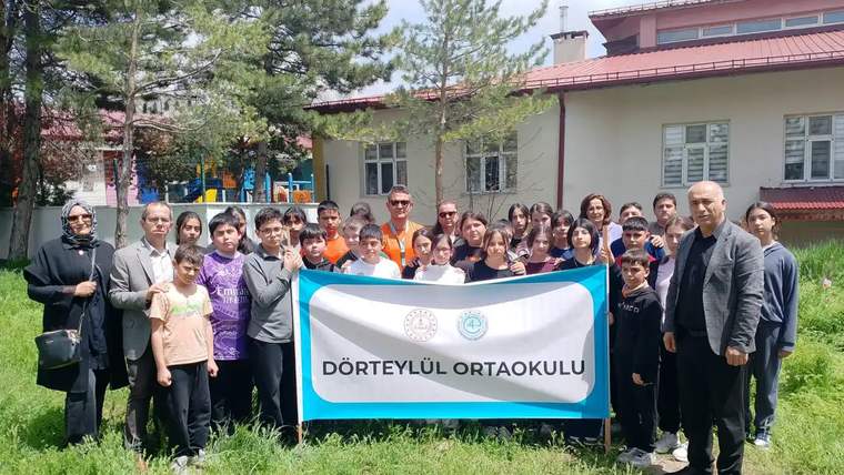Dörtyol Ortaokulu öğrencileri, fidan dikimi etkinliğinde bir araya gelerek toplu fotoğraf çekiliyor.