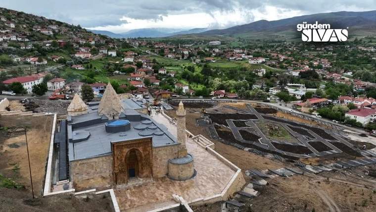 Taş yapılı bir cami kompleksi, çevresindeki yerleşim ve dağlık araziyle birlikte havadan görülüyor.
