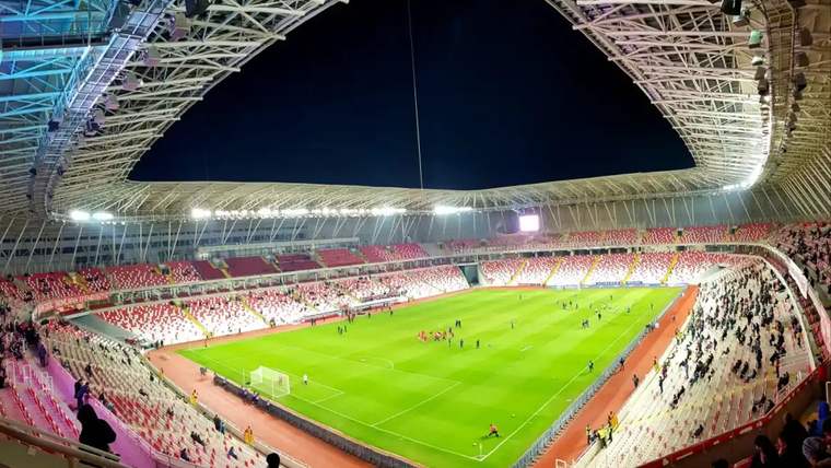 Sivasspor'un stadyumu, yeşil futbol sahası ve boş tribünler görünmekte.