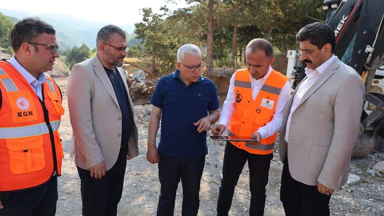 Geminbeli Tüneli'nde inceleme yapan beş kişi, bir tablet üzerinde bilgi paylaşıyor.