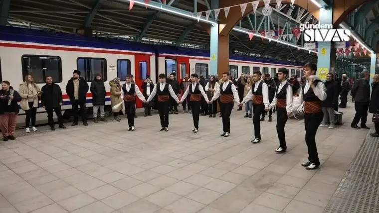 Sivas garında, gelen yolcular için halay çeken sekiz kişi, geleneksel kıyafetler giymekte.