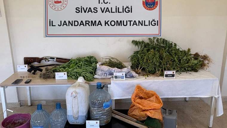 Sivas İl Jandarma Komutanlığı tabelası önünde bitki demetleri, poşetler, bidonlar ve çeşitli malzemeler sergileniyor.