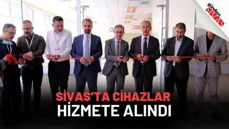 Kurdele kesen bir grup erkek, yeni cihazların açılışını yapıyor.