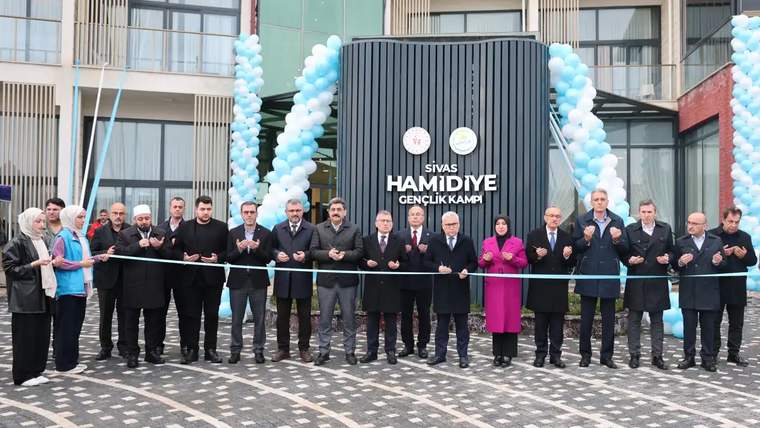 Kurdele kesen kalabalık, arka planda Hamidiye Gençlik Kampı binası ve mavi balonlar.