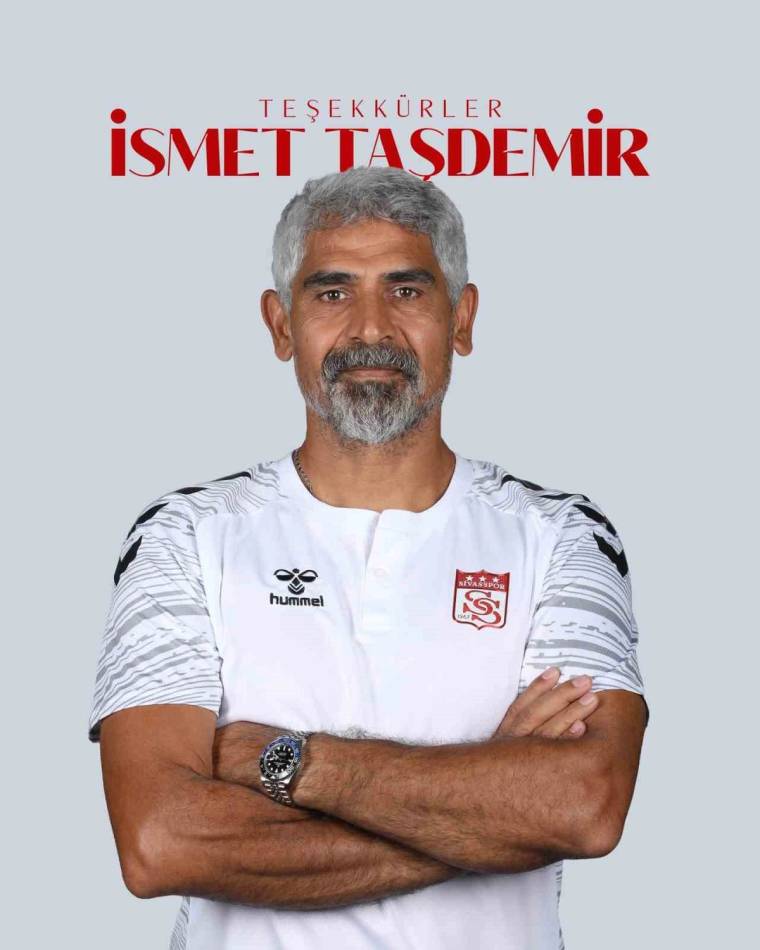 Gri saçlı ve sakallı bir adam, üzerinde kulüp arması bulunan beyaz formayla kollarını kavuşturuyor; üstte “Teşekkürler İsmet Taşdemir” yazıyor.