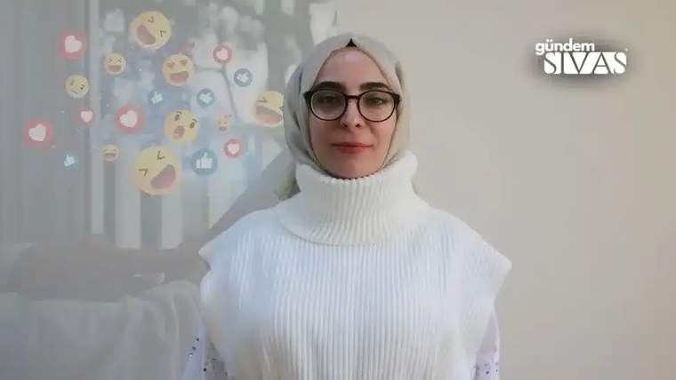 Beyaz bir kazak giymiş, başında başörtüsü olan bir kadın, arka planda sosyal medya simgeleriyle birlikte poz veriyor.