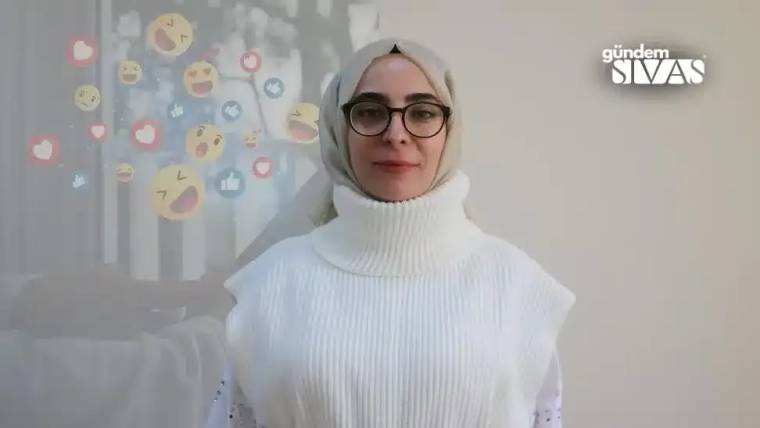 Beyaz bir kazak giymiş, başında başörtüsü olan bir kadın, arka planda sosyal medya simgeleriyle birlikte poz veriyor.