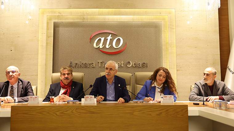 Ankara Ticaret Odası yazılı duvar önünde, masada oturan beş kişi toplantı yapıyor.
