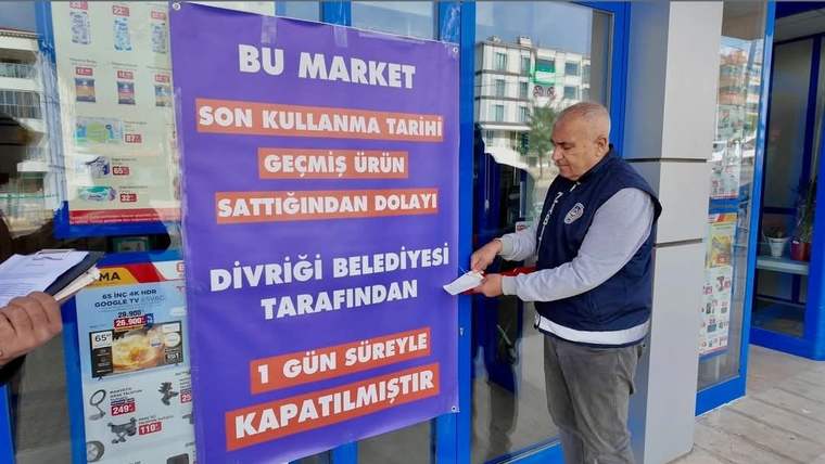 Market girişinde, son kullanma tarihi geçmiş ürün satışı nedeniyle kapatıldığını belirten büyük bir duyuru asılı.