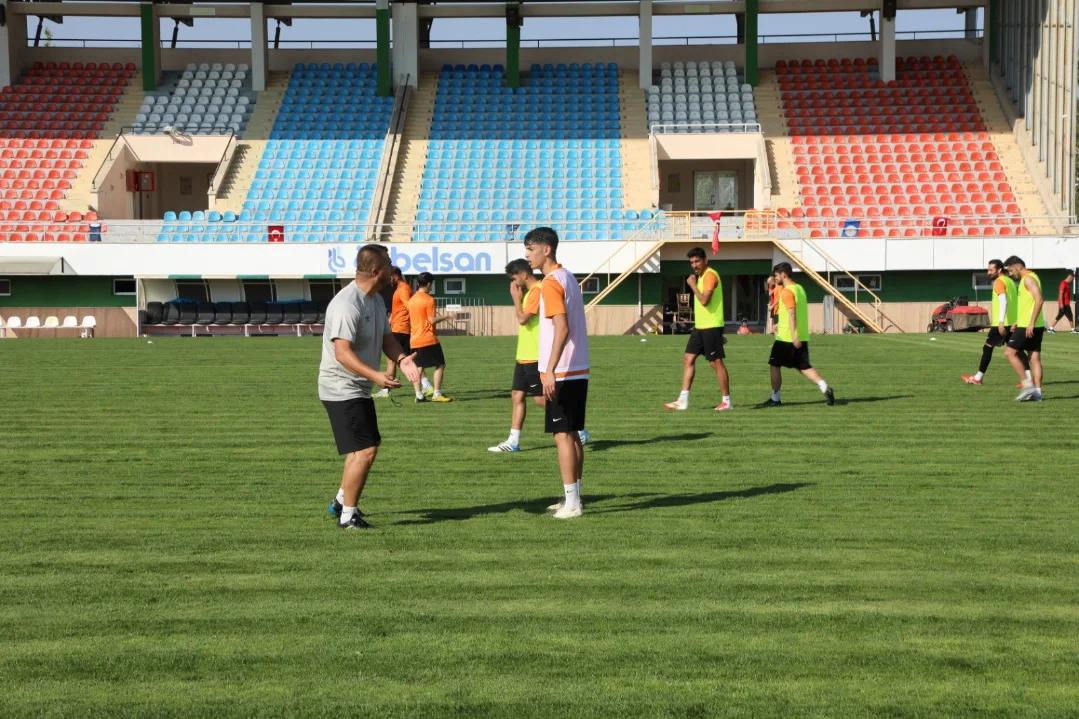 Futbol sahasında antrenman yapan oyuncular, teknik ekip ile birlikte çalışıyor.