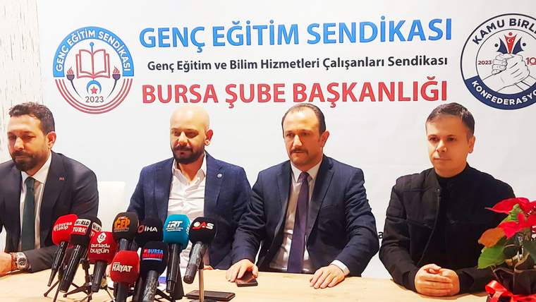 Masada oturan dört kişi ve önlerindeki mikrofonlar, arkada Genç Eğitim Sendikası Bursa Şube Başkanlığı yazısı görülüyor.