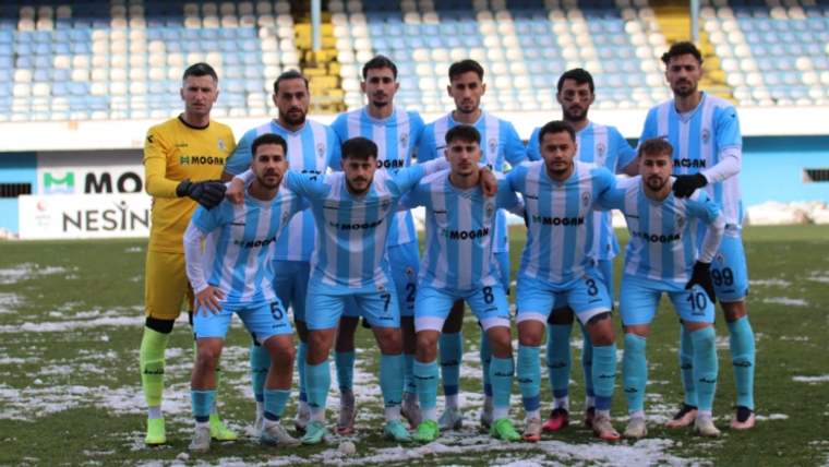 Pazarspor futbol takımı, kış şartlarında karla kaplı sahada poz veriyor.