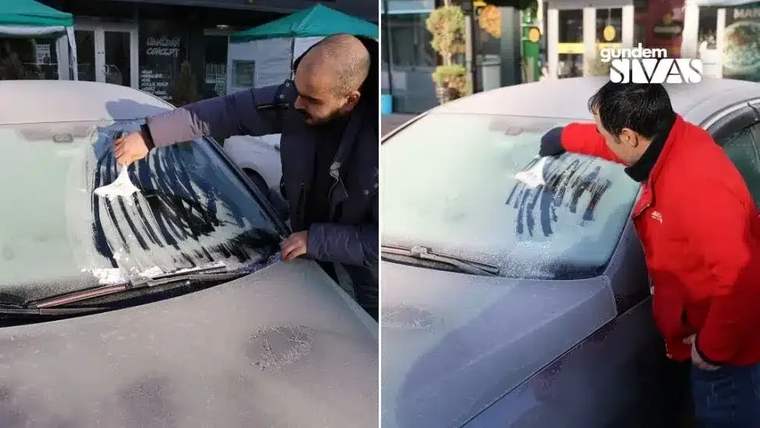 İki kişi, bir aracın ön camındaki buzları kazıyor.