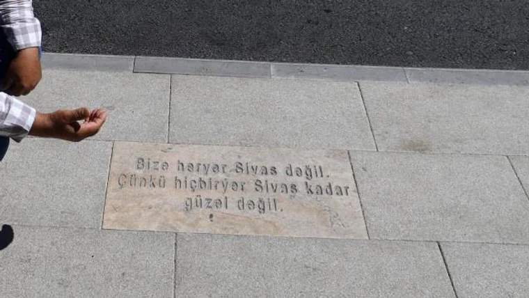 Kaldırımda, Sivas ile ilgili bir şiir yazılı taş plaka yer alıyor.