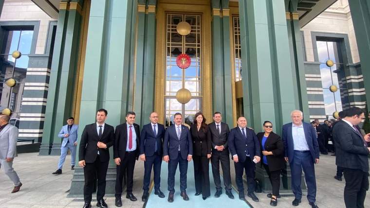 Cumhurbaşkanlığı binası önünde, sekiz kişi bir arada poz veriyor.