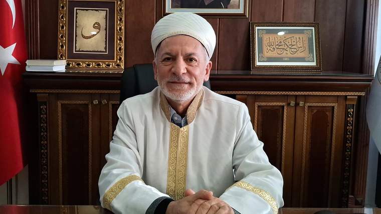 Beypazarı Müftüsü, masanın arkasında oturmuş, beyaz cübbe ve sarık giymiş.