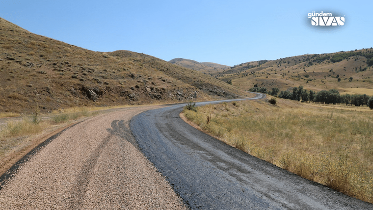 Yenilenen yol, kırsal alanda, dağlık bir arazide kıvrılarak ilerliyor.