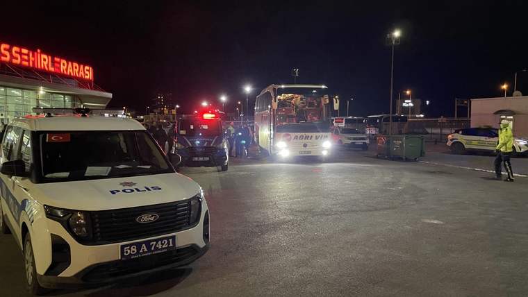 Gece aydınlatılan alanda bir polis aracı, ambulans ve otobüsün yanında görev yapan ekipler görülüyor.