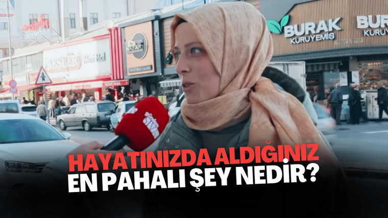 Başında başörtüsü olan bir kadın, mikrofonla sokakta birine soru soruyor.
