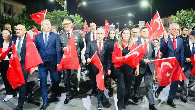 Gece saatlerinde çok sayıda kişinin Türk bayrakları taşıyarak caddede yürüdüğü, aralarında üniformalı bir kişinin bulunduğu görülüyor.