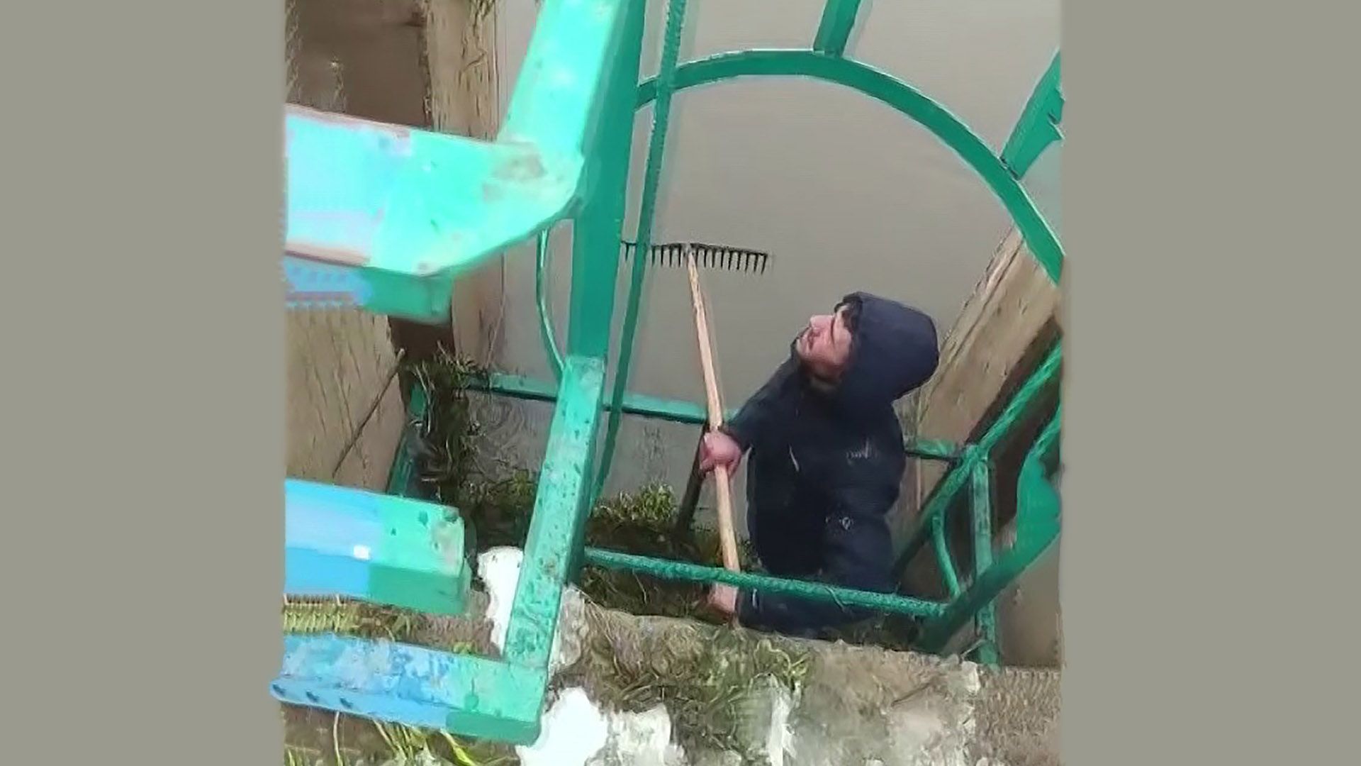 Baraj kapaklarını temizleyen bir kişi, elinde bir tırmıkla çalışıyor.