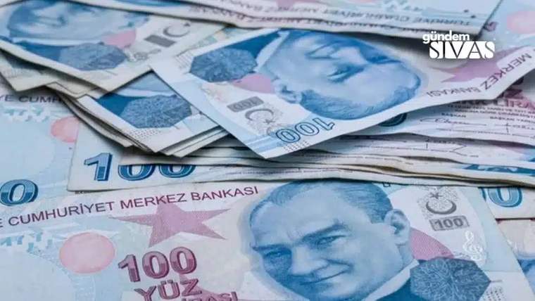 Üzerinde Atatürk resmi bulunan 100 liralık banknotlar, masanın üzerinde dağınık bir şekilde yer alıyor.