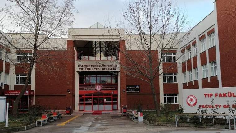 Süleyman Demirel Üniversitesi Tıp Fakültesi binası, önünde giriş kapısı ve tabelalar görünmekte.