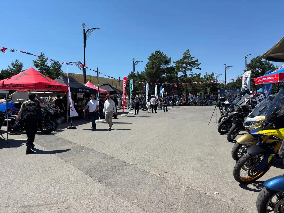Motofest alanında çeşitli motosikletler ve stantlar yer alıyor, katılımcılar dolaşıyor.