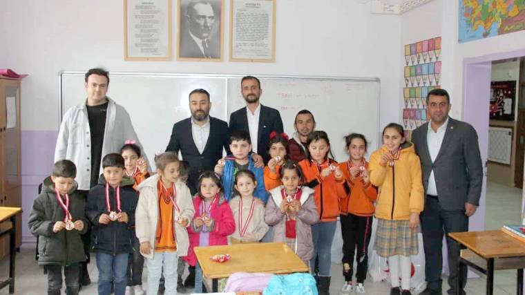 Korkut İlkokulu'nda öğrenciler, madalyalarla birlikte poz veriyorlar.
