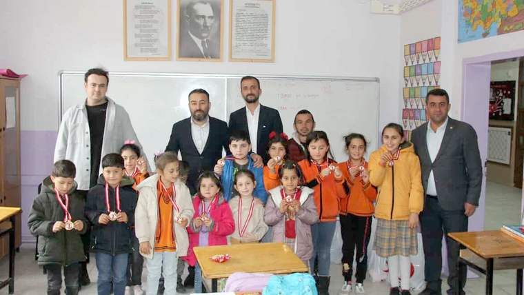 Korkut İlkokulu'nda öğrenciler, madalyalarla birlikte poz veriyorlar.
