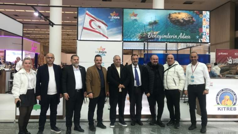 KKTC ve Ankara turizmini tanıtan bir grup insan, stant önünde poz veriyor.
