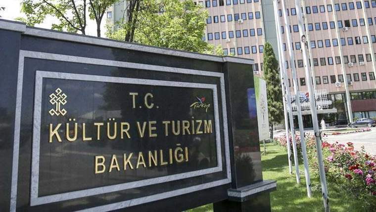 Üzerinde “T.C. Kültür ve Turizm Bakanlığı” yazan taş tabela, ağaçlar ve yüksek binalar önünde duruyor.