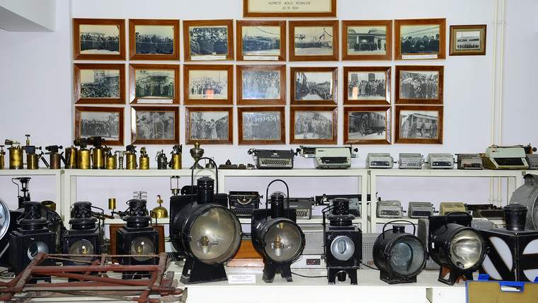 TÜRASAŞ Müzesi'nde sergilenen antika demiryolu parçaları ve arka planda eski fotoğraflar.