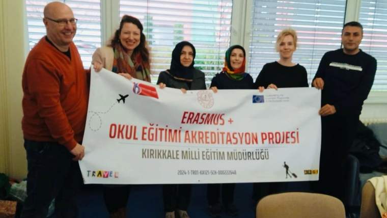 Altı kişi, üzerinde Erasmus+ Okul Eğitimi Akreditasyon Projesi yazan büyük bir pankartı tutuyor.
