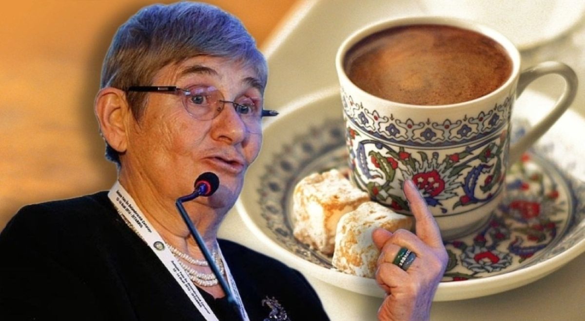 Mikrofonla konuşan gözlüklü bir kadın ile yanında fincan ve tabağındaki Türk kahvesi görülüyor.
