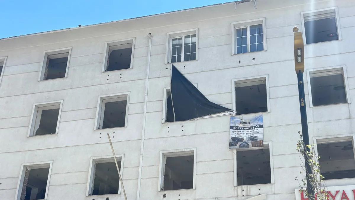 Eski Kızılay Hastanesi binasının dış cephesi, pencereleri kapalı ve bir pencereden siyah bir örtü sarkıyor.