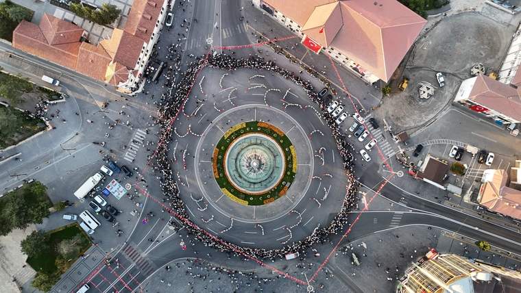 Havadan görülen meydanın çevresinde çok sayıda kişi, merkezdeki yuvarlak havuzun etrafında halkalar oluşturuyor.