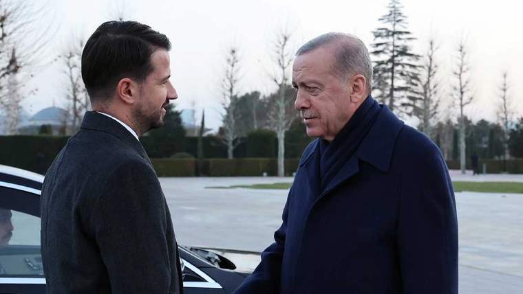Cumhurbaşkanı Erdoğan, resmi törenle karşılaştığı bir kişiyle el sıkışıyor.