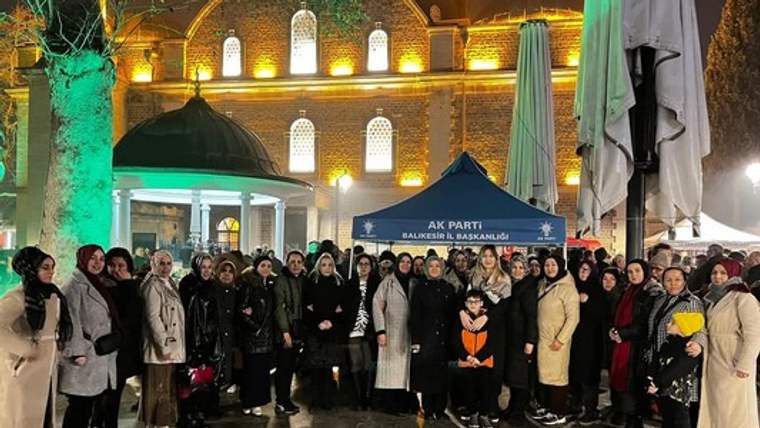 Aydınlatılmış kubbeli yapı önünde, üzerinde AK Parti Balıkesir İl Başkanlığı yazan pankartla toplu duran kalabalık.