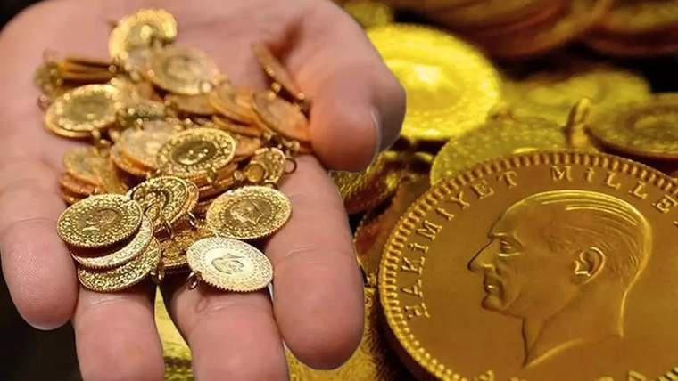 Bir elde çeşitli altın sikkeler, yanında ise büyük bir portre kabartmalı altın madalya bulunuyor.