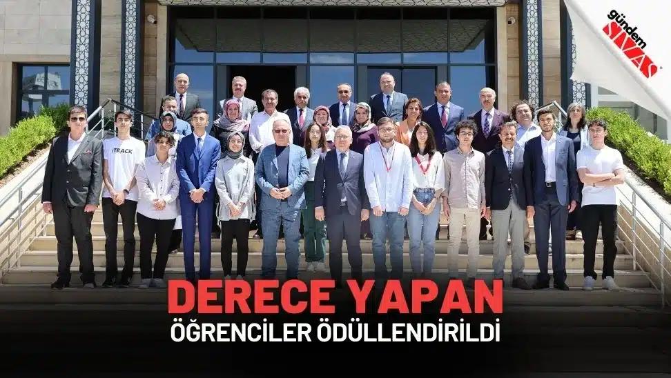 Ödül törenine katılan öğrenciler ve yetkililer, bina önünde topluca poz veriyor.