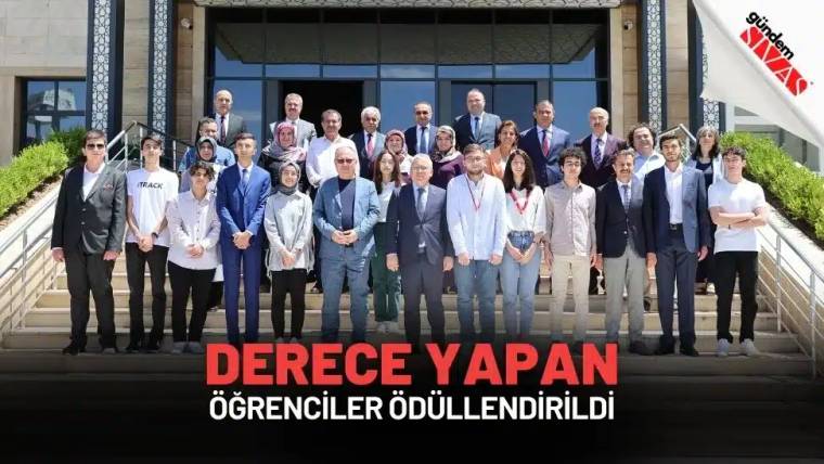 Ödül törenine katılan öğrenciler ve yetkililer, bina önünde topluca poz veriyor.