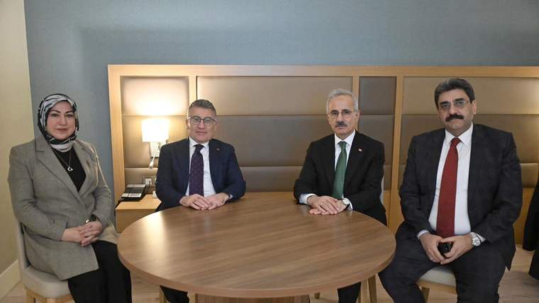 Bir masanın etrafında oturan dört kişi, arka planda aydınlatma ve mobilyalar görünüyor.