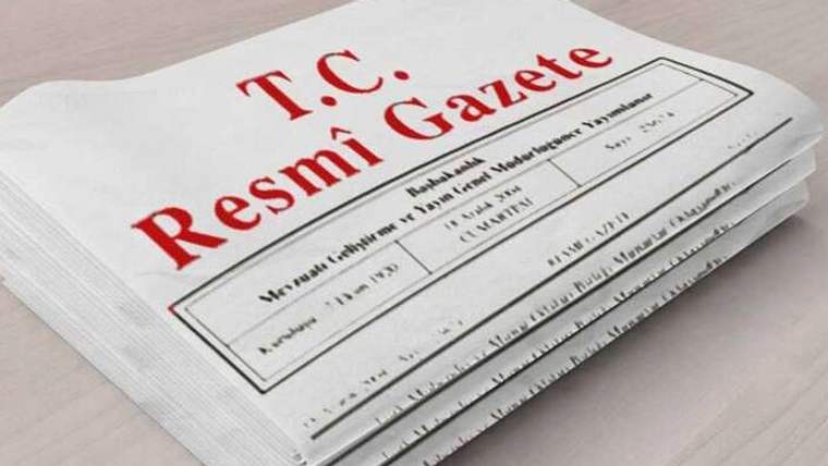 Masa üzerinde üst sayfasında “T.C. Resmî Gazete” yazan üst üste dizilmiş gazete nüshaları