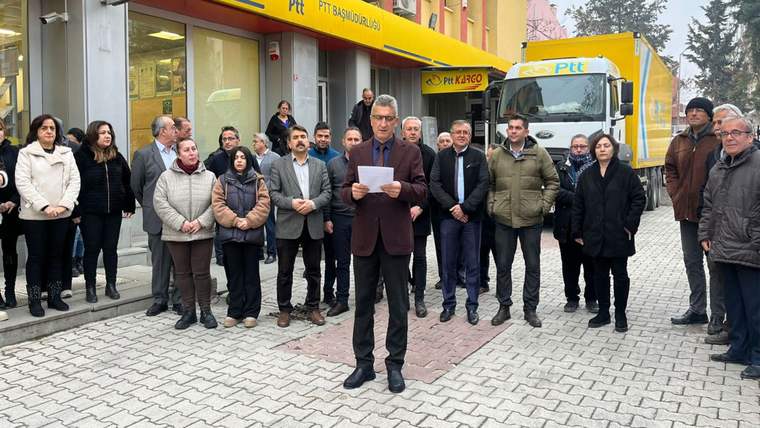 PTT şubesi önünde toplanan kalabalığın ortasında bir kişi elindeki metni okurken görülüyor.
