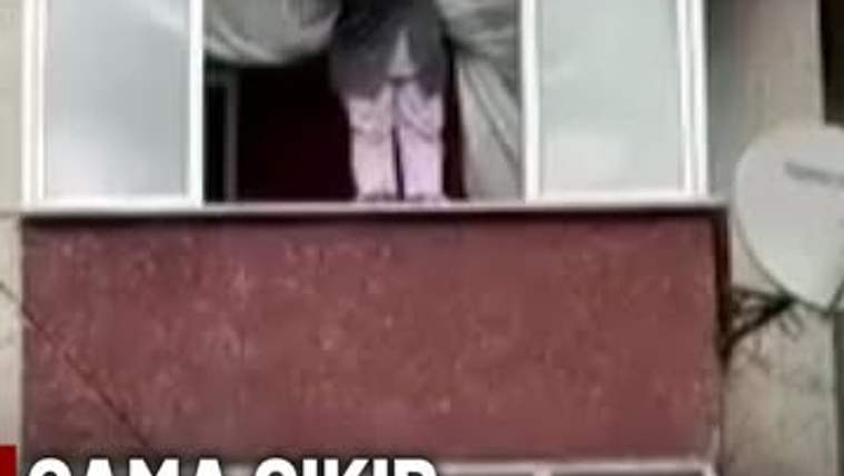 Açık pencereden dışarı sarkan bir kadın, üst kattaki binanın penceresinde görülüyor; altta yazı bulunuyor.